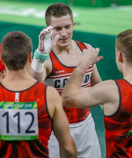 The University of Calgary's Jackson Payne celebrates, along with other members of the Canadian men's artistic gymnastics team, at the 2018 Commonwealth Games in Gold Coast, Australia.