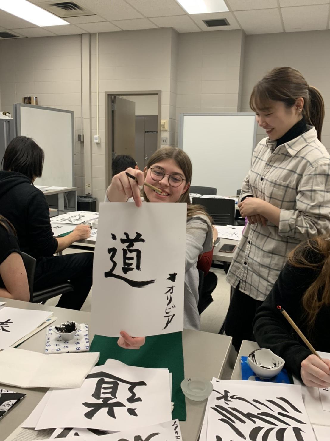 Student proudly displays calligraphy work