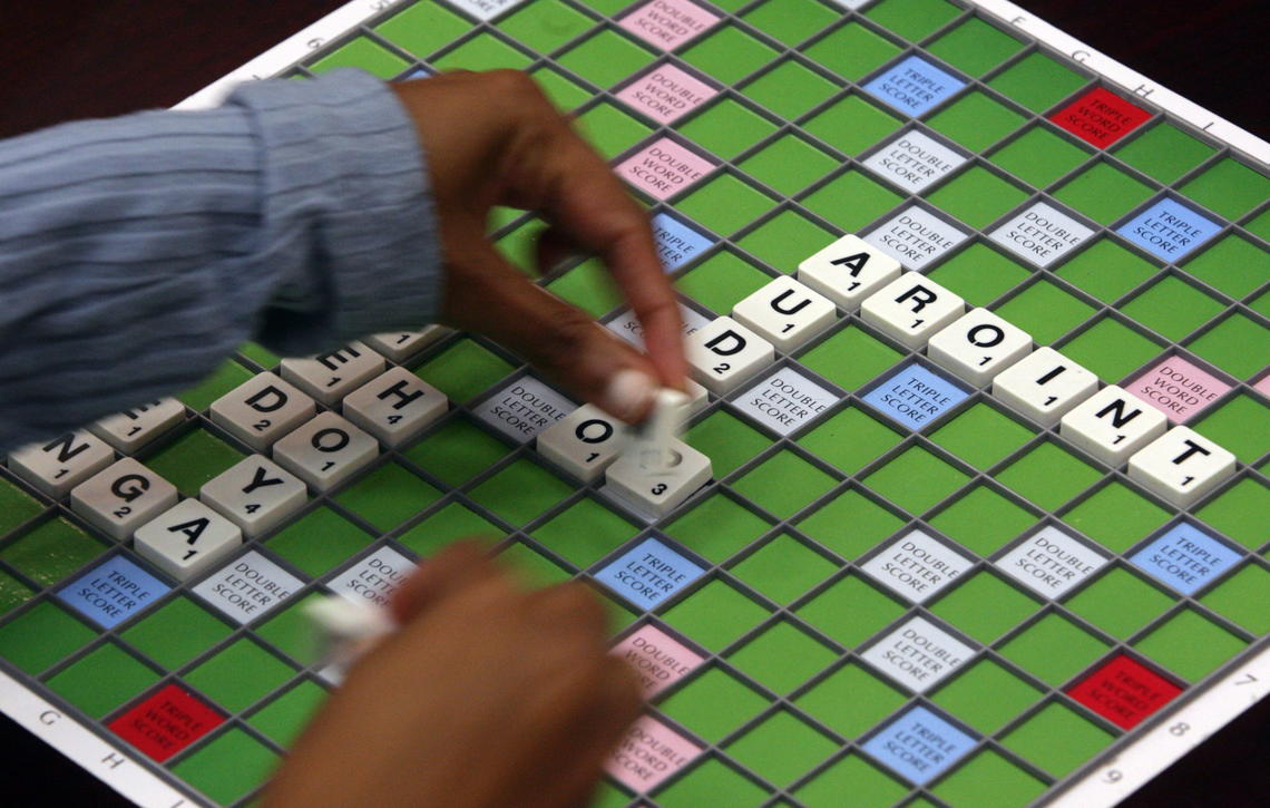 A Scrabble player places tiles to spell a word during a meeting of the Vancouver Scrabble Club. 