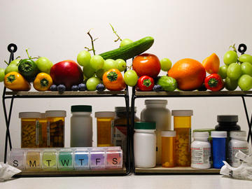 Two shelves with peppers, tomatoes, other vegetables and medications