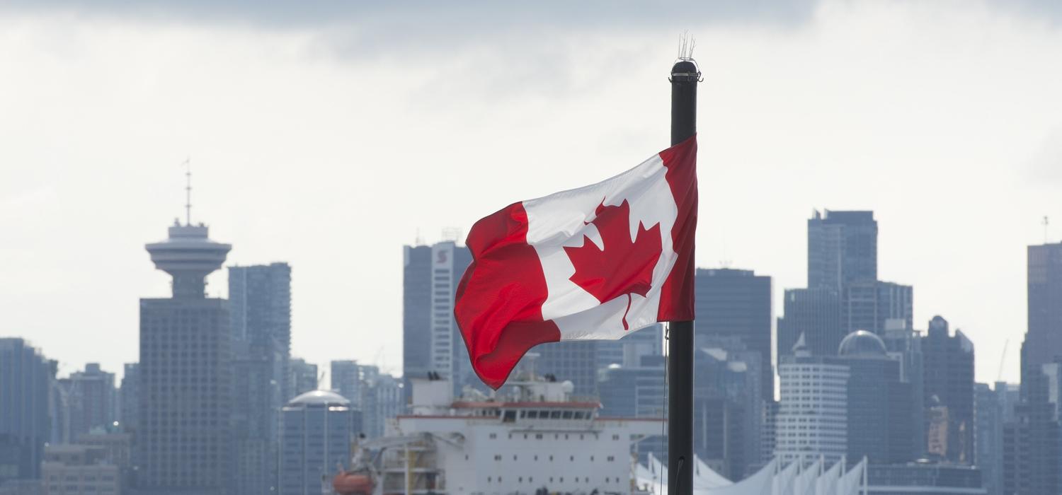  Universities face pressure to ensure their graduate programs have a clear return on investment both for students and for taxpayers. Here, the Vancouver skyline behind a Canadian flag in North Vancouver, B.C., March 24, 2020. 