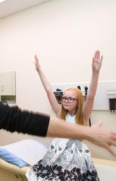 Dr. Susanne Benseler leads Kayla Baayens in mobility tests. The 10-year-old has an aggressive form of childhood arthritis. Benseler is part of an international team that received $8 million in grants to bring precision medicine to children suffering from childhood arthritis. Photo by Riley Brandt, University of Calgary