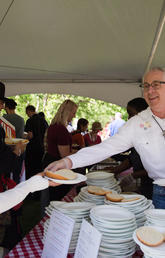 President Ed McCauley serves up barbecue at the annual President’s Stampede Barbecue on July 3. 