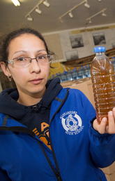 In an photo from 2016, Potlotek First Nation resident Patricia Paul holds a sample of water she says came from her taps at home.