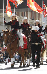 Stampede cowgirls carrying Calgary Stampede flags 