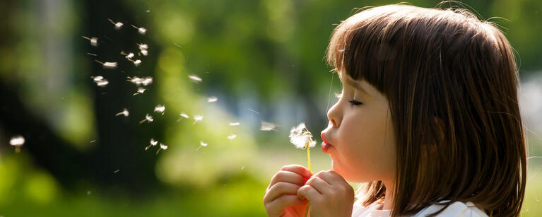 6 year old girl blowing bubbles outside