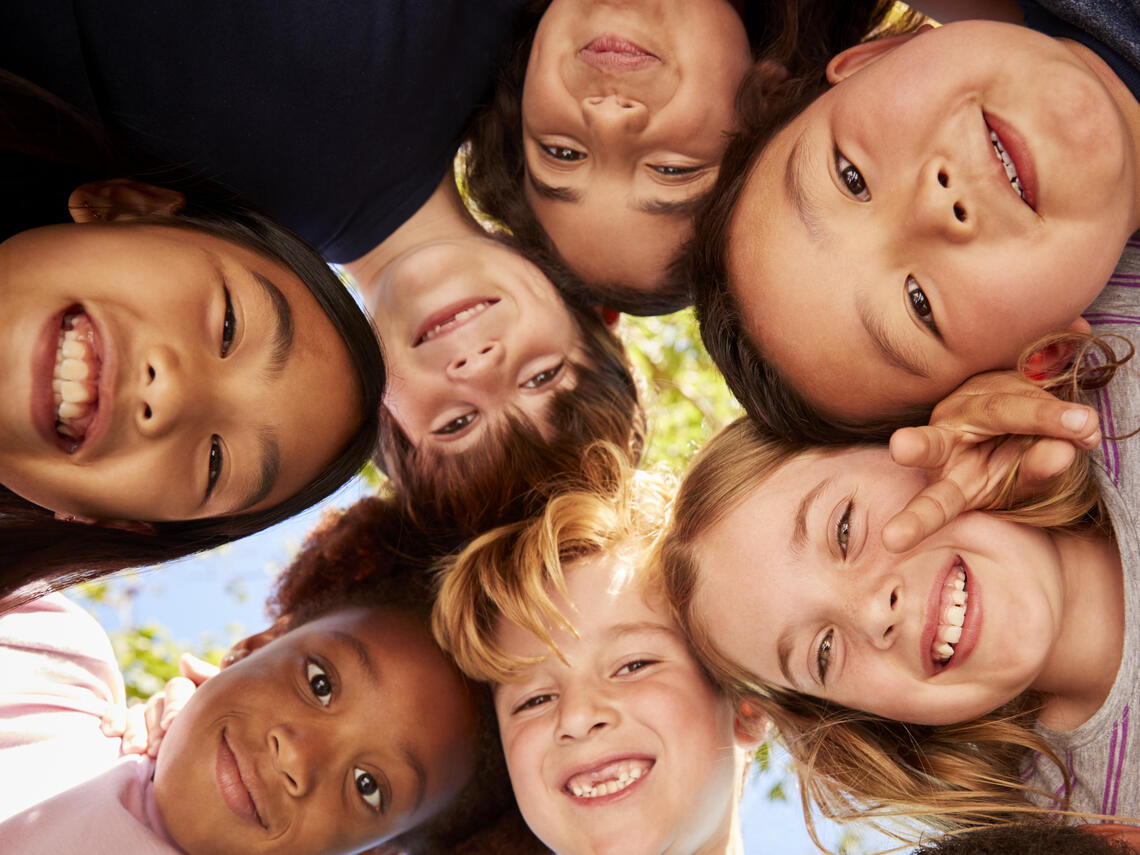 kids standing in a circle looking down at camera