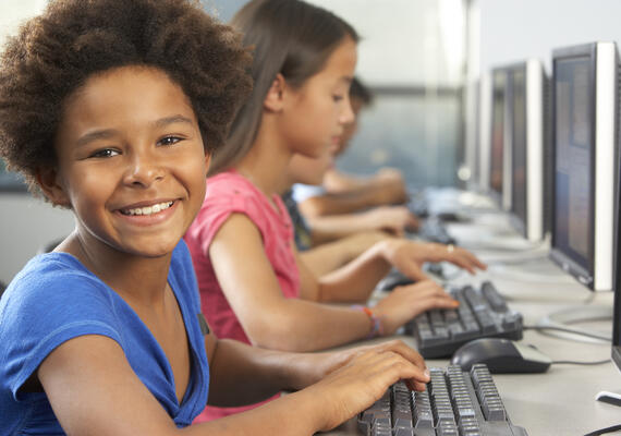 preteen typing at computer