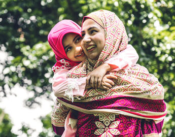 girlgirl wrapped around mom's shoulder