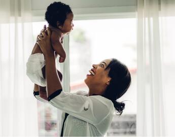 mom holding up baby